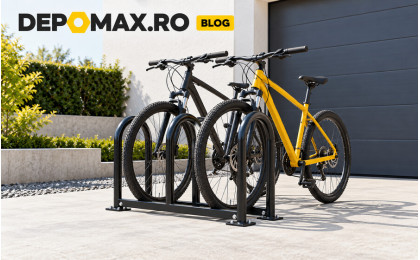 Suport metalic ancorat pentru biciclete, realizat din țeavă rotundă și platbandă, montat lângă un garaj modern